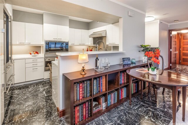 415 S St Unit 4202, Honolulu, HI 96813 - kitchen featuring extractor fan, ornamental molding, light countertops, dark marble finish flooring, and white cabinets