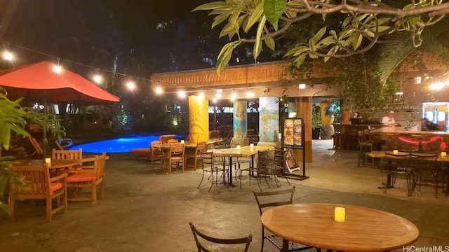 2425 Kuhio Ave Unit 410, Honolulu, HI 96815 - patio at twilight with outdoor dining area, a pergola, an outdoor pool, and a patio