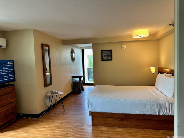 2425 Kuhio Ave Unit 410, Honolulu, HI 96815 - bedroom with wood finished floors, an AC wall unit, and baseboards