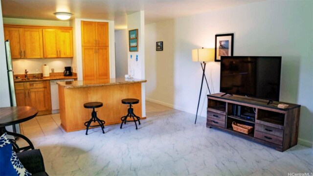 57-120 Lalo Kuilima Way Unit 2/17, Kahuku, HI 96731 - kitchen featuring a kitchen island, a breakfast bar, white dishwasher, stone counters, and a sink