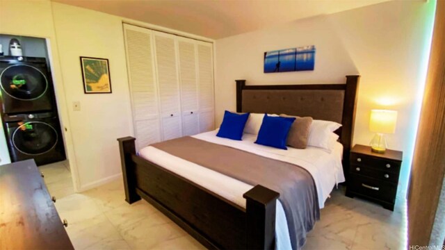 57-120 Lalo Kuilima Way Unit 2/17, Kahuku, HI 96731 - bedroom featuring light marble finish flooring, stacked washer and clothes dryer, and a closet