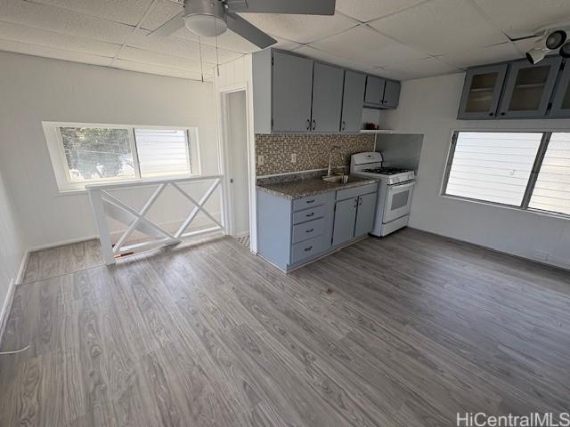 1704 Kamamalu Ave, Honolulu, HI 96813 - kitchen featuring white gas stove, gray cabinets, ceiling fan, a paneled ceiling, and decorative backsplash