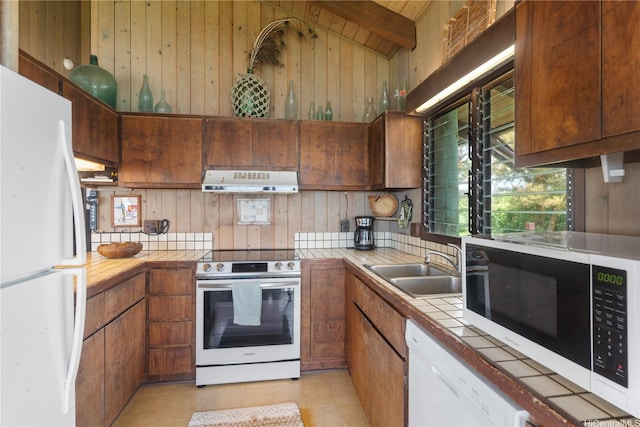 56-189 Kamehameha Hwy, Kahuku, HI 96731 - kitchen with white appliances, tile counters, under cabinet range hood, a sink, and wooden walls