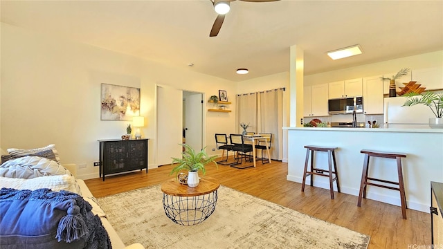 91-540 Puamaeole St Unit 49D, Ewa Beach, HI 96706 - living area featuring light wood finished floors, ceiling fan, and baseboards
