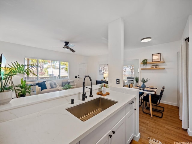 91-540 Puamaeole St Unit 49D, Ewa Beach, HI 96706 - kitchen with white cabinetry, light stone countertops, ceiling fan, open floor plan, and light wood-type flooring