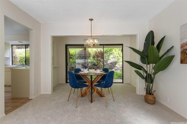 1630 Kalaniiki St Unit 31, Honolulu, HI 96821 - carpeted dining area featuring healthy amount of natural light, a chandelier, a textured ceiling, and baseboards