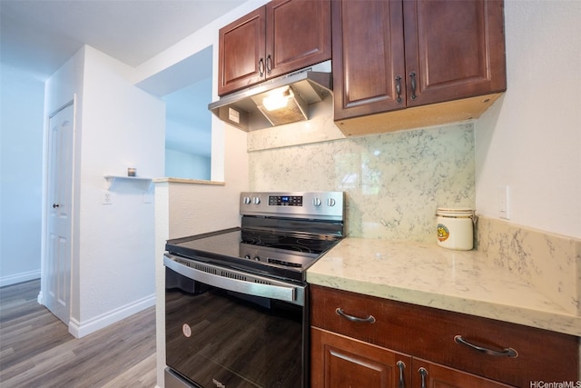 92-1210 Makakilo Dr Unit 5, Kapolei, HI 96707 - kitchen with stainless steel electric range oven, under cabinet range hood, light wood-type flooring, tasteful backsplash, and light stone countertops