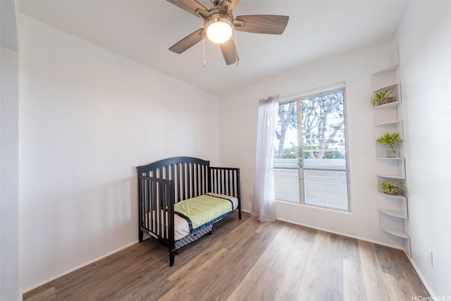 92-1210 Makakilo Dr Unit 5, Kapolei, HI 96707 - bedroom with wood finished floors, ceiling fan, baseboards, and a nursery area