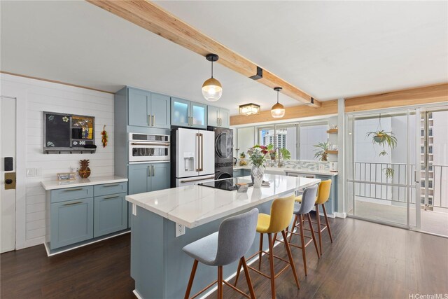 419 Keoniana St Unit 1003, Honolulu, HI 96815 - kitchen featuring white appliances, dark wood-type flooring, stacked washer and clothes dryer, a breakfast bar area, and beam ceiling