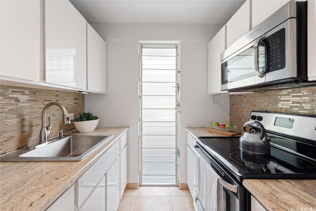 1670 Kalakaua Ave Unit 205, Honolulu, HI 96826 - kitchen featuring appliances with stainless steel finishes, white cabinetry, decorative backsplash, light countertops, and a textured ceiling
