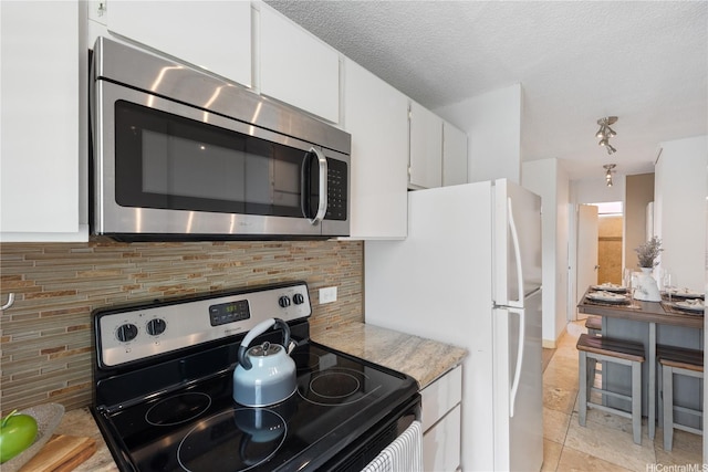 1670 Kalakaua Ave Unit 205, Honolulu, HI 96826 - kitchen with appliances with stainless steel finishes, light countertops, backsplash, white cabinets, and a textured ceiling