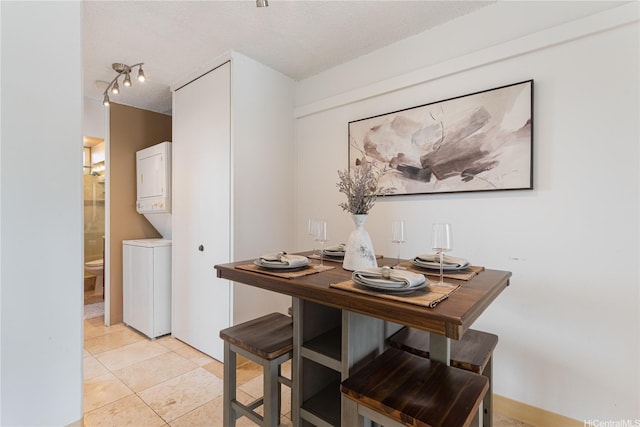 1670 Kalakaua Ave Unit 205, Honolulu, HI 96826 - dining room featuring stacked washer / drying machine, light tile patterned flooring, track lighting, and a textured ceiling