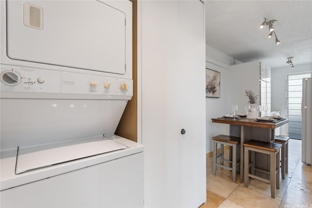 1670 Kalakaua Ave Unit 205, Honolulu, HI 96826 - laundry room featuring stacked washer / drying machine, a textured ceiling, light tile patterned floors, and track lighting
