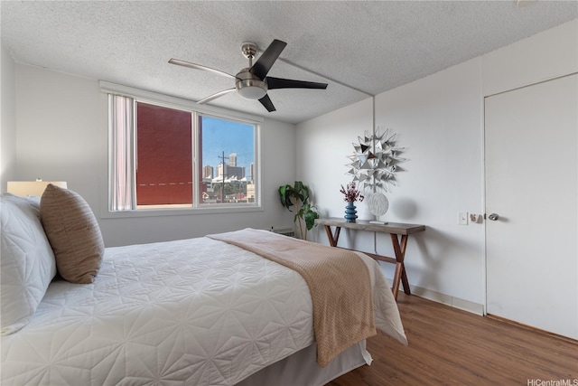 1670 Kalakaua Ave Unit 205, Honolulu, HI 96826 - bedroom with wood finished floors, a textured ceiling, and a ceiling fan