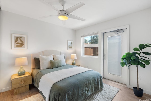 1310 Pensacola St Unit 106, Honolulu, HI 96814 - bedroom with light wood-type flooring, access to exterior, a ceiling fan, and baseboards