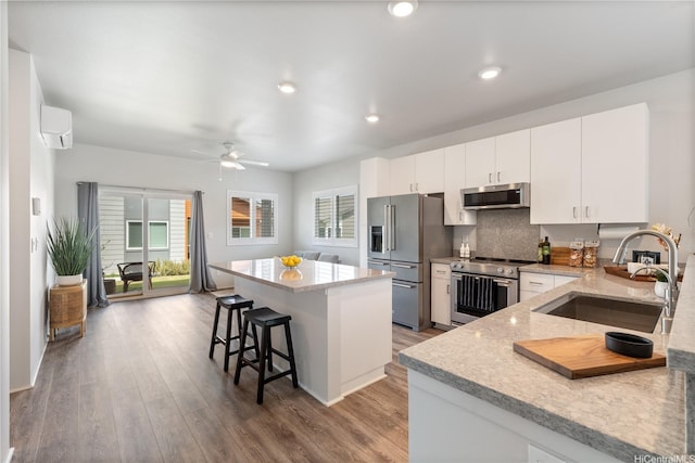 91-1785 Kohanahana Loop, Ewa Beach, HI 96706 - kitchen featuring stainless steel appliances, a sink, a kitchen bar, a center island, and ceiling fan