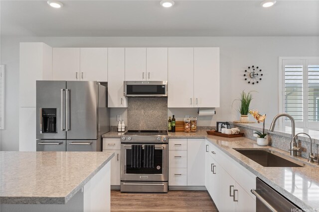 91-1785 Kohanahana Loop, Ewa Beach, HI 96706 - kitchen featuring appliances with stainless steel finishes, a sink, wood finished floors, recessed lighting, and white cabinets