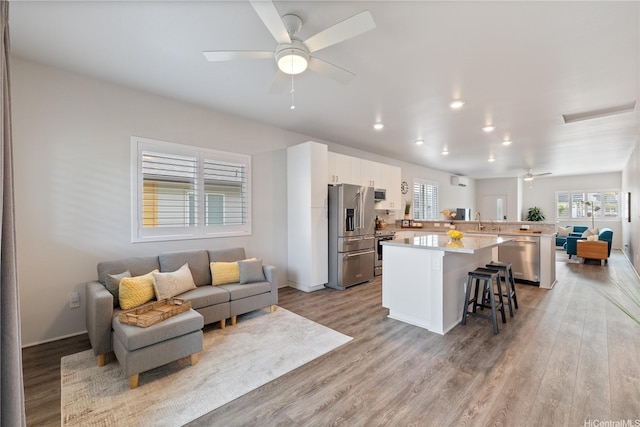 91-1785 Kohanahana Loop, Ewa Beach, HI 96706 - kitchen featuring stainless steel appliances, open floor plan, a ceiling fan, a kitchen bar, and a kitchen island