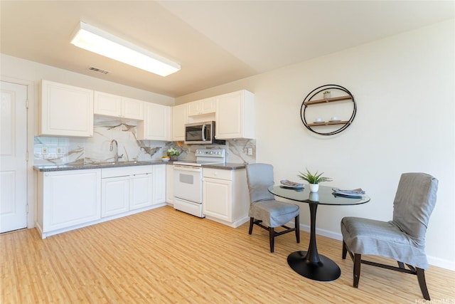 91-1031 Kaimalie St Unit 4P4, Ewa Beach, HI 96706 - kitchen with electric range, stainless steel microwave, backsplash, a sink, and white cabinetry