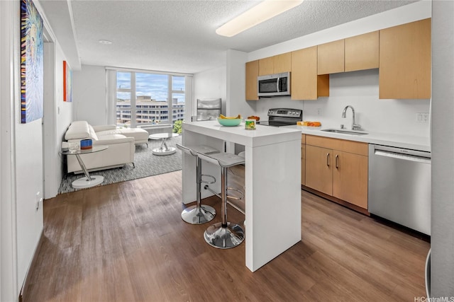 7000 Hawaii Kai Dr Unit 2702, Honolulu, HI 96825 - kitchen with appliances with stainless steel finishes, wood finished floors, light countertops, expansive windows, and a breakfast bar