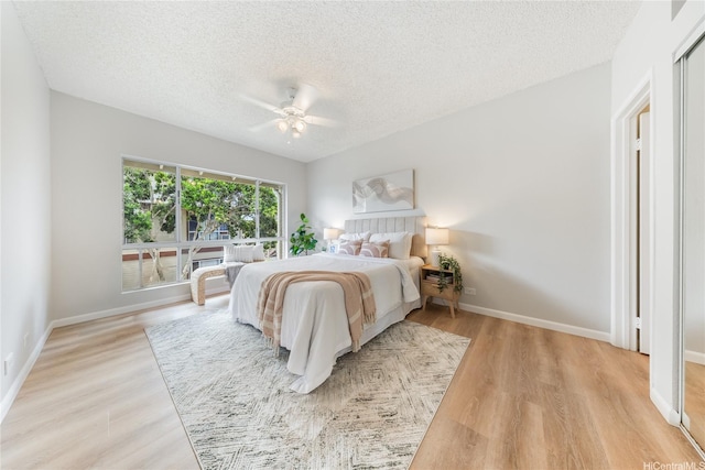 91-1059 Puaniu St Unit 21T, Ewa Beach, HI 96706 - bedroom with a textured ceiling, light wood-type flooring, baseboards, and ceiling fan