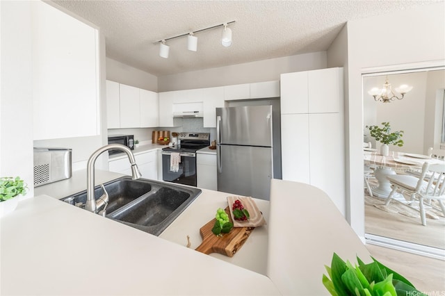 91-1059 Puaniu St Unit 21T, Ewa Beach, HI 96706 - kitchen featuring appliances with stainless steel finishes, a sink, rail lighting, light countertops, and white cabinets