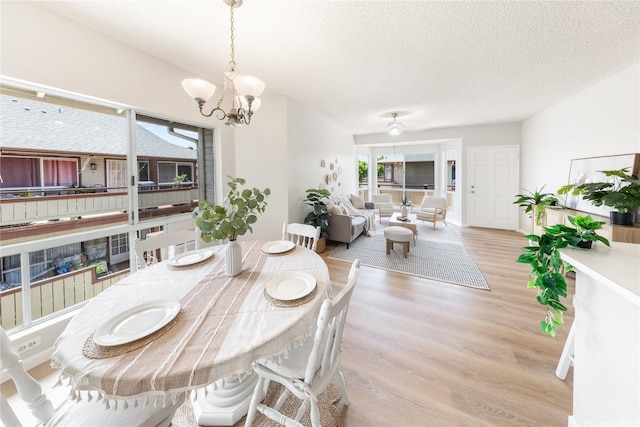 91-1059 Puaniu St Unit 21T, Ewa Beach, HI 96706 - dining space featuring light wood-style floors, a chandelier, and a textured ceiling