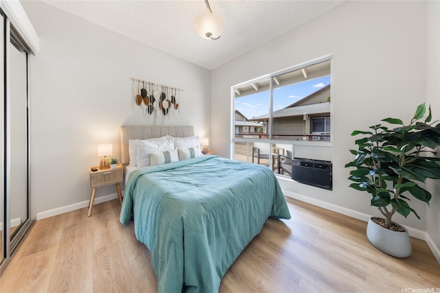 91-1059 Puaniu St Unit 21T, Ewa Beach, HI 96706 - bedroom with wood finished floors, baseboards, lofted ceiling, and a textured ceiling