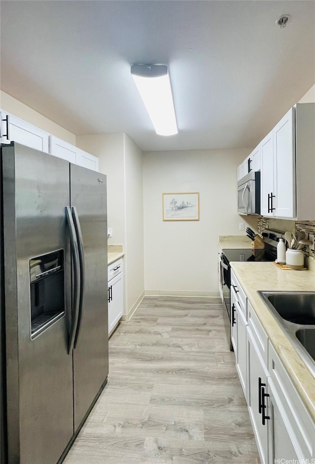 91-1227 Kamaaha Ave Unit 302, Kapolei, HI 96707 - kitchen with stainless steel appliances, light countertops, light wood-style flooring, white cabinetry, and a sink