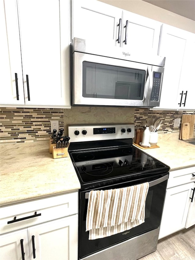 91-1227 Kamaaha Ave Unit 302, Kapolei, HI 96707 - kitchen with stainless steel appliances, white cabinets, tasteful backsplash, and light stone countertops