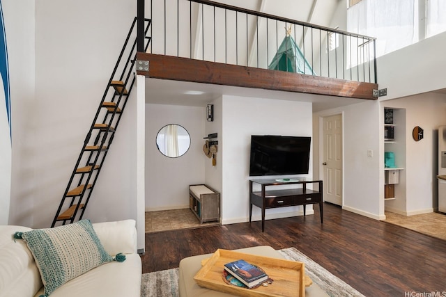 94-423 Keaoopua St Unit 155, Mililani, HI 96789 - living area with wood finished floors, a towering ceiling, stairs, baseboards, and healthy amount of natural light