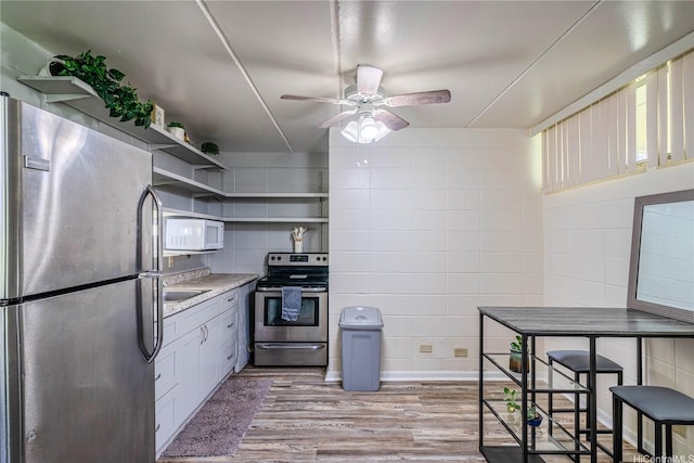 95-024 Waihau St Unit 16A, Mililani, HI 96789 - kitchen with stainless steel appliances, open shelves, light wood finished floors, a ceiling fan, and light countertops