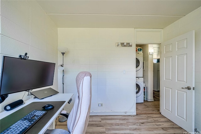95-024 Waihau St Unit 16A, Mililani, HI 96789 - washroom featuring stacked washer and clothes dryer, tile walls, light wood-type flooring, and a desk