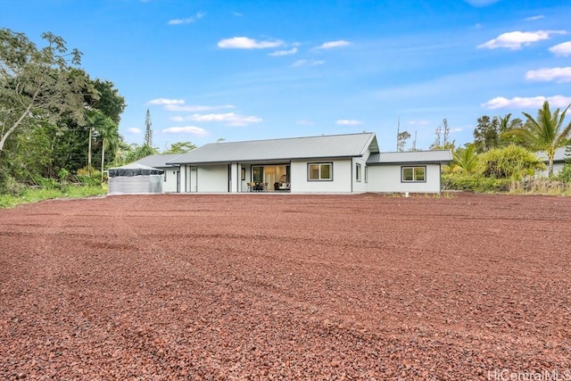 ranch-style house featuring metal roof and a patio area