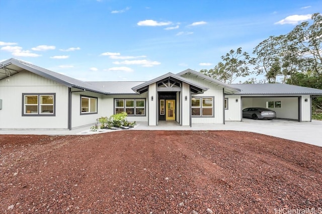 view of front of property featuring concrete driveway, an attached garage, and metal roof