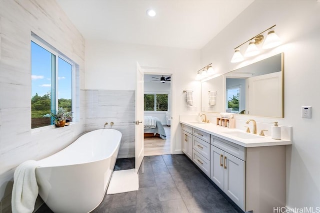 bathroom with ceiling fan, a soaking tub, double vanity, ensuite bathroom, and recessed lighting