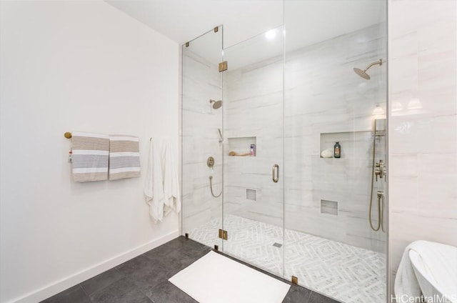 full bath with a shower stall, baseboards, and tile patterned flooring