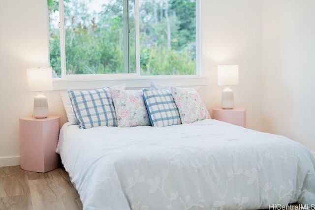 bedroom with baseboards and wood finished floors