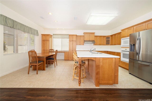 91-1104 Kaileonui St, Ewa Beach, HI 96706 - kitchen featuring white appliances, under cabinet range hood, light countertops, glass insert cabinets, and an island with sink