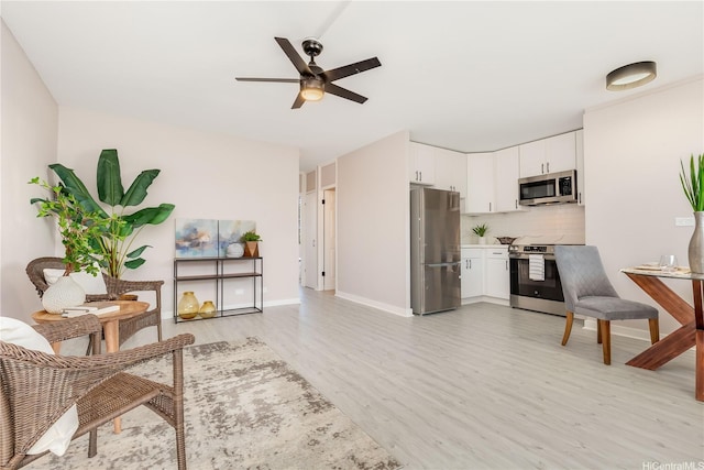 94-249 Waikele Rd Unit A205, Waipahu, HI 96797 - kitchen featuring stainless steel appliances, light wood-style floors, a ceiling fan, decorative backsplash, and white cabinetry
