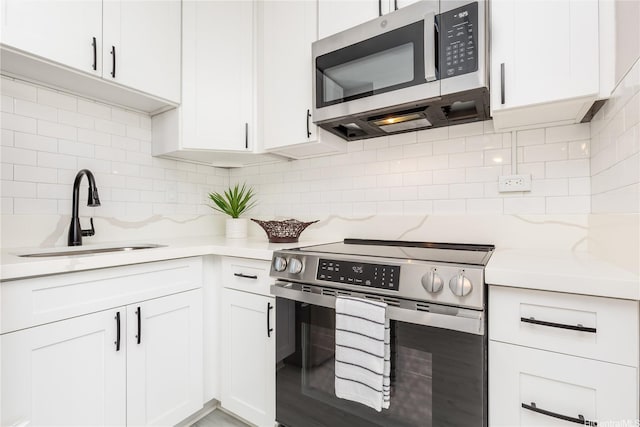 94-249 Waikele Rd Unit A205, Waipahu, HI 96797 - kitchen featuring stainless steel appliances, a sink, backsplash, and white cabinetry