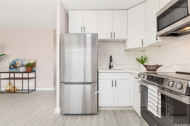 94-249 Waikele Rd Unit A205, Waipahu, HI 96797 - kitchen featuring stainless steel appliances, a sink, light wood-style floors, and white cabinets