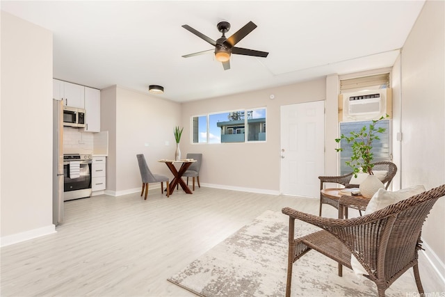 94-249 Waikele Rd Unit A205, Waipahu, HI 96797 - living room with light wood-style flooring, a wall unit AC, a ceiling fan, and baseboards