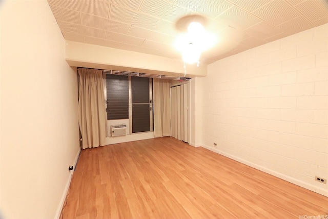 2626 Kuilei St Unit K, Honolulu, HI 96826 - empty room featuring light wood-type flooring, baseboards, and a wall mounted air conditioner