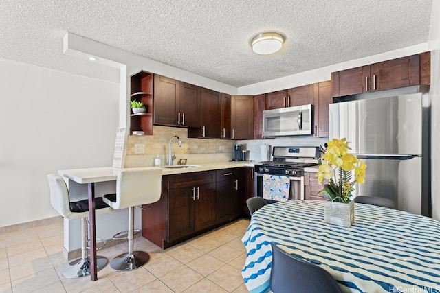 2452 Tusitala St Unit 1101, Honolulu, HI 96815 - kitchen featuring stainless steel appliances, a sink, open shelves, light countertops, and decorative backsplash
