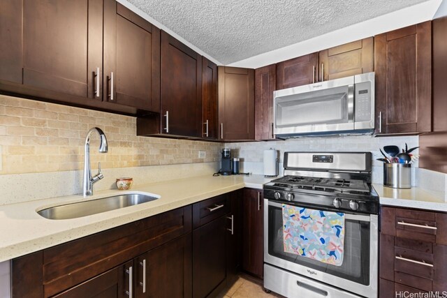 2452 Tusitala St Unit 1101, Honolulu, HI 96815 - kitchen with appliances with stainless steel finishes, a sink, a textured ceiling, backsplash, and dark brown cabinets