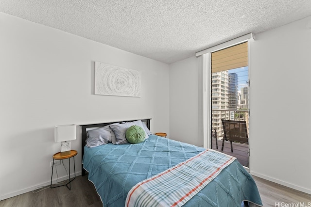 2452 Tusitala St Unit 1101, Honolulu, HI 96815 - bedroom featuring wood finished floors, a textured ceiling, access to exterior, and baseboards