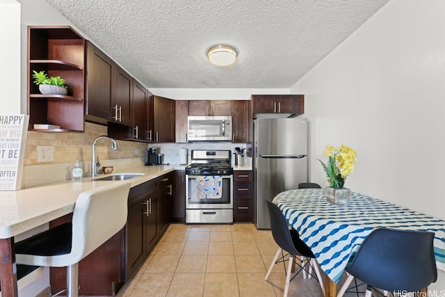 2452 Tusitala St Unit 1101, Honolulu, HI 96815 - kitchen with appliances with stainless steel finishes, a sink, open shelves, dark brown cabinets, and tasteful backsplash