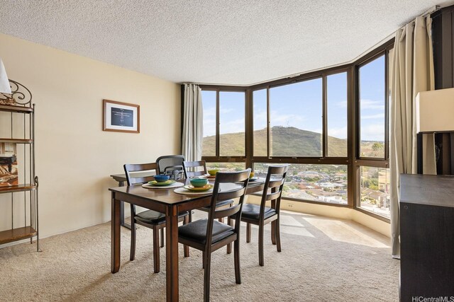5070 Likini St Unit 1409, Honolulu, HI 96818 - dining room with light carpet, floor to ceiling windows, plenty of natural light, a textured ceiling, and a mountain view