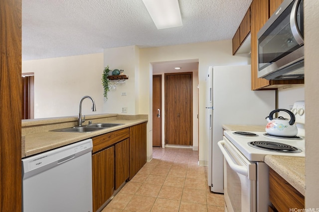 5070 Likini St Unit 1409, Honolulu, HI 96818 - kitchen featuring white appliances, a sink, light countertops, a textured ceiling, and brown cabinetry